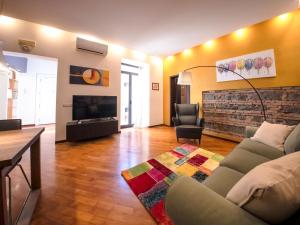 a living room with a couch and a television at Zagara Luxury Home in Catania