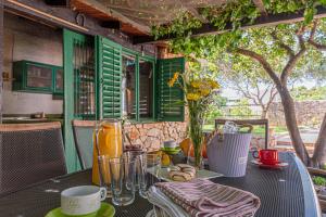 une table avec des assiettes et des verres sur une table avec un arbre dans l'établissement Villa Mariah with pool near National park Krka, à Bilice