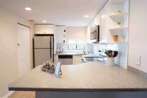 a kitchen with white cabinets and a counter top at Stroll to Siesta Beach from Serene Condo + (bikes) in Siesta Key
