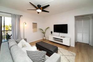 a living room with a couch and a flat screen tv at Stroll to Siesta Beach from Serene Condo + (bikes) in Siesta Key