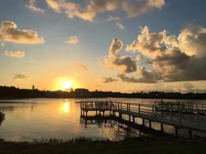 a pier on a lake with the sunset in the background at Stroll to Siesta Beach from Serene Condo + (bikes) in Siesta Key