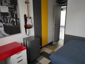 a bedroom with a guitar on the wall and a bed at T3 PRADO St-GINIEZ in Marseille