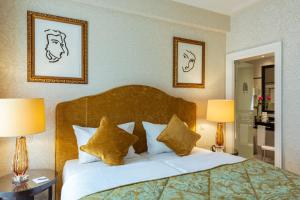 a bedroom with a bed with pillows and two lamps at Grand Hotel Casselbergh in Bruges