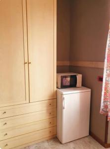 eine Mikrowelle auf einem Kühlschrank neben einem Schrank in der Unterkunft Appartamento dentro Roma in Rom