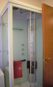 a bathroom with a glass shower with a red towel at Appartamento dentro Roma in Rome