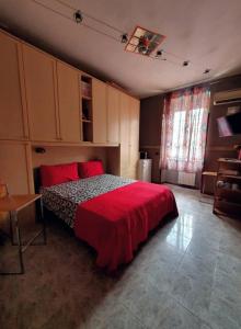Schlafzimmer mit einem Bett mit einer roten Bettdecke in der Unterkunft Appartamento dentro Roma in Rom