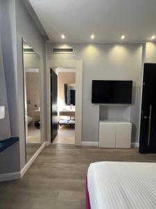 een slaapkamer met een bed en een flatscreen-tv bij The Unique Hotel in Milaan