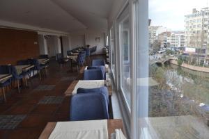 a restaurant with tables and chairs and a large window at Manzara Hotel in Eskisehir