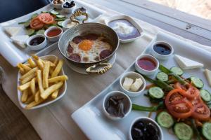 una bandeja de comida con un huevo y papas fritas en Manzara Hotel en Eskisehir