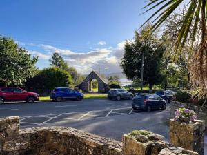 a parking lot with cars parked in front of a church at The Cupán in Mountshannon