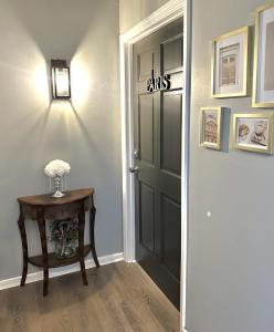 a hallway with a door and a table with flowers on it at Speedway Legacy Inn in Indianapolis