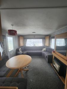 a living room with a couch and a table at Kingfisher OAK 1098 Dees Caravan Lettings in Ingoldmells