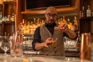 a man standing behind a bar preparing a drink at Sheraton Grand Seattle in Seattle