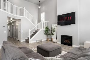 a living room with a couch and a fireplace at 8 Beds 2 Full Kitchens Fenced HUGE Yard & Parks! in Saratoga Springs