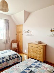 a bedroom with two beds and a wooden dresser at Villa Dorota in Zakopane