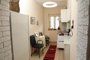 a small kitchen with a table and a chair at Central Fortuzi Apartment in Tirana