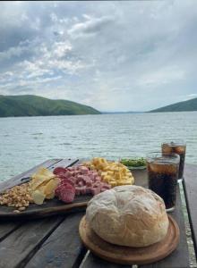 una bandeja de comida en una mesa junto al agua en Cabañas Cabra Corral en Coronel Moldes