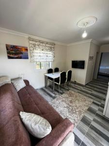 a living room with a couch and a table at Duranapart Fethiye in Fethiye