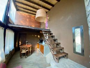 a room with a staircase in a house with a table at Cabañas Cabra Corral in Coronel Moldes