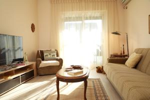 a living room with a couch and a table at Central Fortuzi Apartment in Tirana
