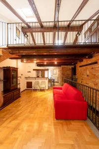 un salon avec un canapé rouge en mezzanine dans l'établissement Peiragal, à La Morra