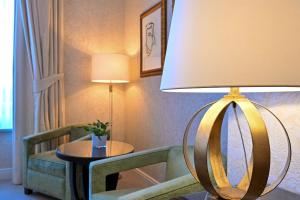 a room with a lamp and a table and chairs at Grand Hotel Casselbergh in Bruges