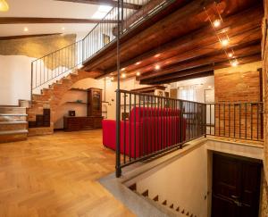 - un salon avec un canapé rouge et des escaliers dans l'établissement Peiragal, à La Morra