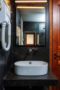 ein Badezimmer mit einem weißen Waschbecken und einem Spiegel in der Unterkunft The View Hotel in Ioannina