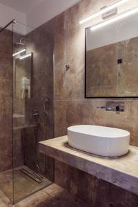 ein Bad mit einem Waschbecken und einer Glasdusche in der Unterkunft The View Hotel in Ioannina