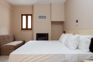 a bedroom with a large white bed and a chair at The View Hotel in Ioannina