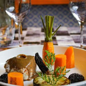 a plate of food with carrots on a table at Brit Hotel Florimont in Saint-Ferréol