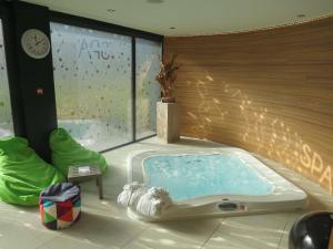 Cette chambre dispose d'un bain à remous et d'une grande fenêtre. dans l'établissement Brit Hotel & Spa Saint Brieuc Plérin, à Plérin