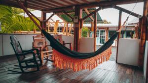 a hammock on a porch with a chair at Eco Hotel Terrabella in Santa Elena