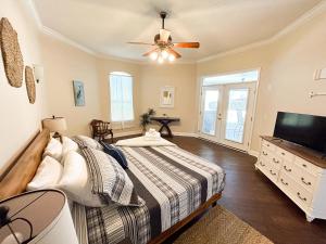 a bedroom with a bed and a flat screen tv at FairHaven Beach Retreat in Navarre
