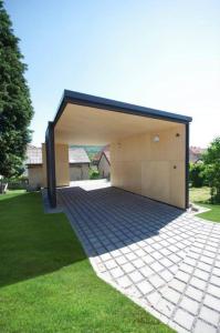 a building with a garage with a brick driveway at Penzion Tsport in Wotitz