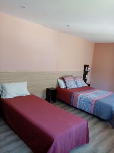 ein Hotelzimmer mit 2 Betten in einem Zimmer in der Unterkunft Brit Hotel St-Quentin/Nord in Saint-Quentin