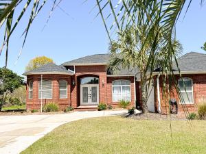 a brick house with a palm tree in front of it at FairHaven Beach Retreat in Navarre