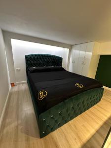 a bedroom with a bed with a black bedspread on it at Rent Room 2 Rolandi Apartments in Pogradec