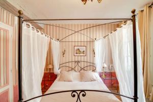 een slaapkamer met een hemelbed en gordijnen bij Brit Hotel Comtes De Champagne - Troyes Centre Historique in Troyes