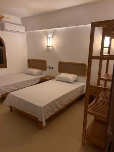 Zimmer mit 2 Betten und einer Leiter in der Unterkunft Tokyo house in Dahab