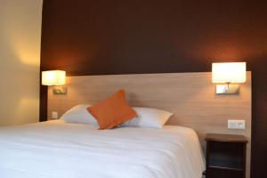 a bedroom with a large bed with two lamps on it at Brit Hotel Essentiel Tours Nord in Tours