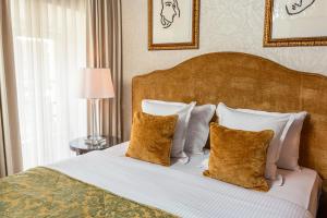 a bedroom with a large bed with white pillows at Grand Hotel Casselbergh in Bruges