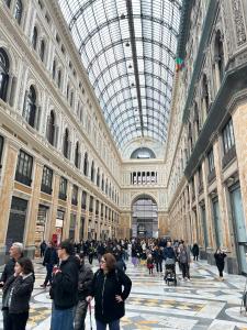 un gruppo di persone che camminano in un edificio con un soffitto di vetro di casa serao a Napoli