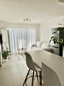 a white living room with a couch and a table at City Centre Apartment in Windhoek in Windhoek