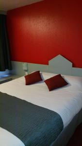 サルグミーヌにあるBrit Hotel Sarregueminesの赤い壁のベッドルーム1室(大型ベッド1台付)