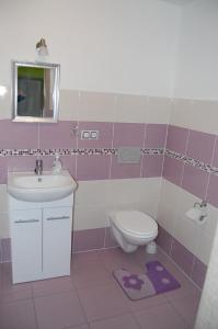 a pink and white bathroom with a sink and a toilet at Apartmán Café u Kordulky in Ratíškovice
