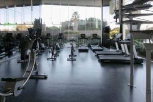 a gym with a row of treadms and machines at Olivo Apartment HP - Sur in Mexico City