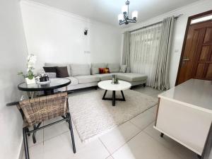 Neema Executive Suites Ngong RD with Balcony في نيروبي: غرفة معيشة مع أريكة وطاولة