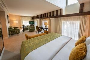 a bedroom with a large bed and a living room at Grand Hotel Casselbergh in Bruges