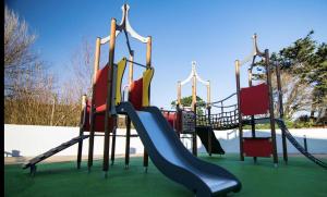 a playground with a slide in a park at 11 Meadow View in Newquay